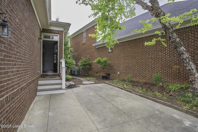 895 Woodlawn Rd Unit 2, Bardstown, KY 40004 - view of exterior entry with brick siding, a patio area, roof with shingles, and crawl space
