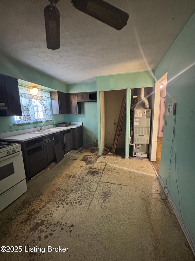 1314 S 36th St, Louisville, KY 40211 - kitchen with white gas range, light countertops, heating unit, a textured ceiling, and a sink