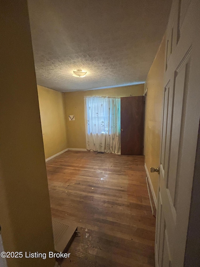 1314 S 36th St, Louisville, KY 40211 - spare room featuring wood finished floors, a textured ceiling, and baseboards