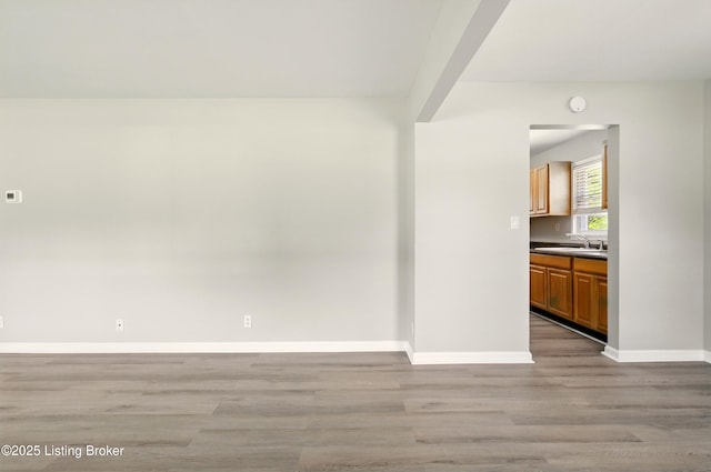 2410 Waco Ct, Louisville, KY 40216 - unfurnished room with a sink, light wood-style floors, and baseboards