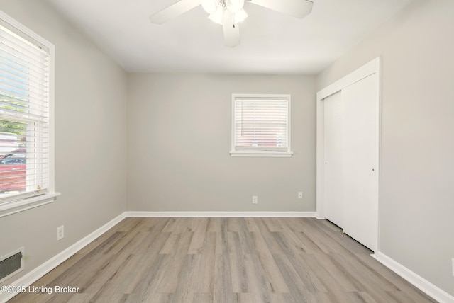 2410 Waco Ct, Louisville, KY 40216 - unfurnished bedroom with light wood-style flooring, multiple windows, and a closet