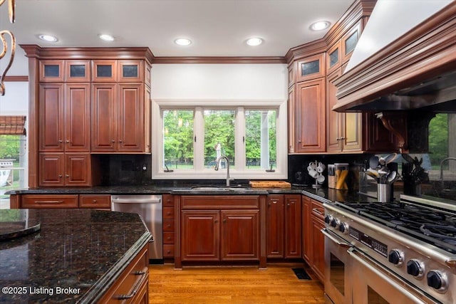 11308 Bodley Dr, Louisville, KY 40223 - kitchen featuring appliances with stainless steel finishes, custom range hood, a sink, backsplash, and light wood-type flooring