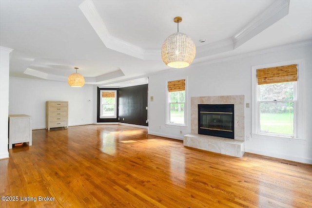 11308 Bodley Dr, Louisville, KY 40223 - unfurnished living room with a tray ceiling, crown molding, wood finished floors, a tiled fireplace, and baseboards