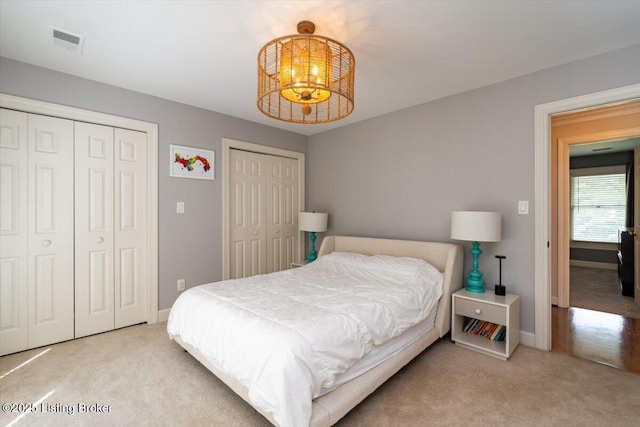 11308 Bodley Dr, Louisville, KY 40223 - carpeted bedroom featuring multiple closets, baseboards, and a chandelier