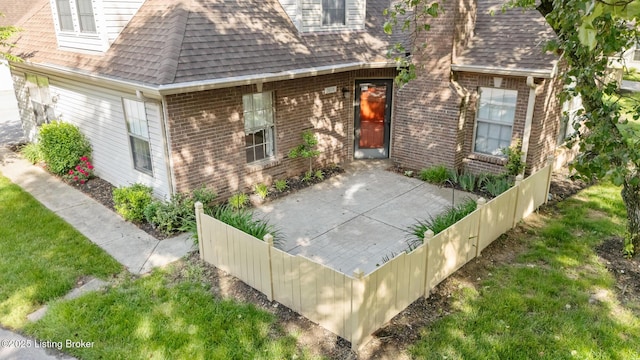 3010 Graystone Manor Pkwy, Louisville, KY 40241 - view of exterior entry featuring brick siding, a shingled roof, and a patio