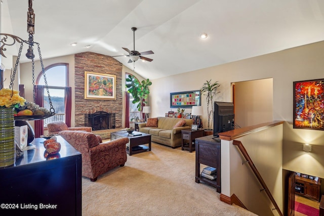 living room featuring vaulted ceiling, ceiling fan, a fireplace, and light colored carpet