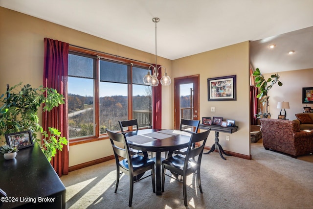 dining area featuring carpet, baseboards, and a chandelier