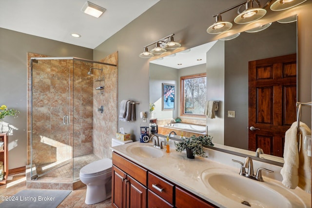 bathroom featuring a shower stall, toilet, a bath, and double vanity