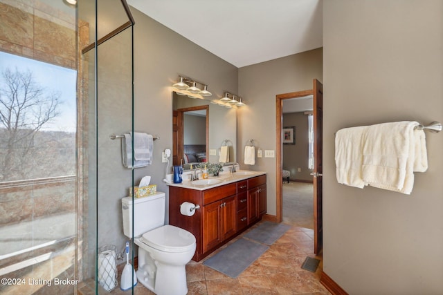 bathroom with tiled shower, double vanity, toilet, and tile patterned flooring