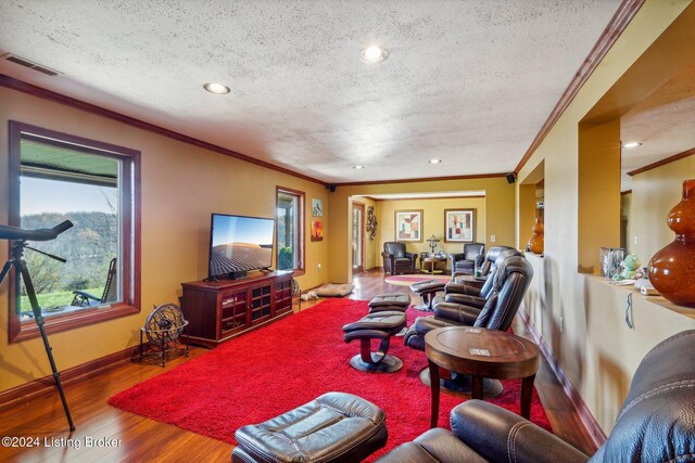 living area with crown molding, a textured ceiling, wood finished floors, baseboards, and recessed lighting