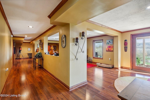 hallway featuring ornamental molding, a textured ceiling, wood finished floors, baseboards, and recessed lighting