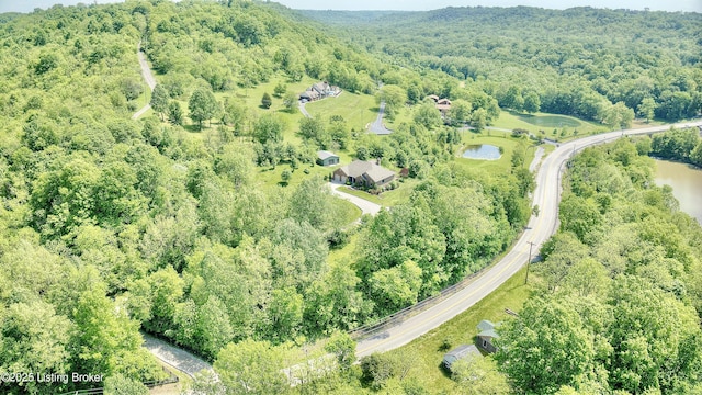 aerial view of property's location with a forest and a large body of water