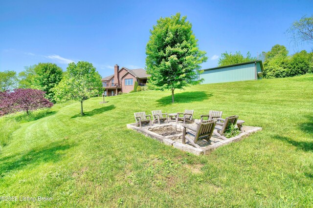 view of green lawn featuring an outdoor fire pit