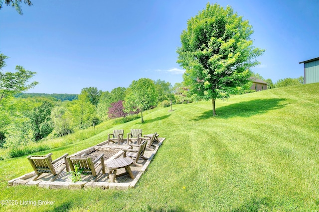 view of grassy yard with a fire pit