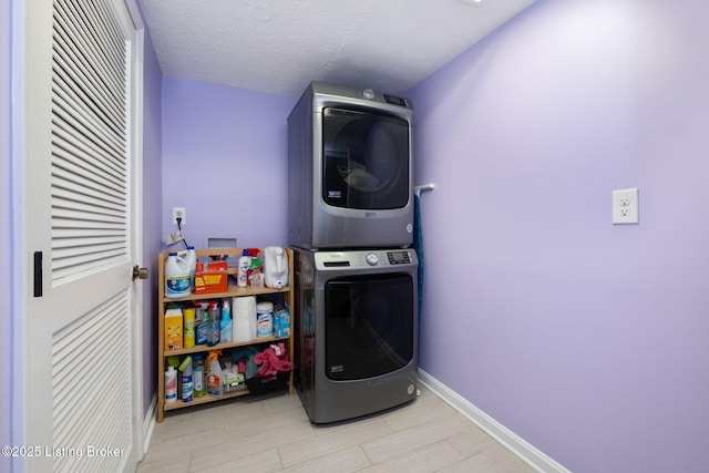 washroom featuring estacked washer and dryer, baseboards, and a heating unit