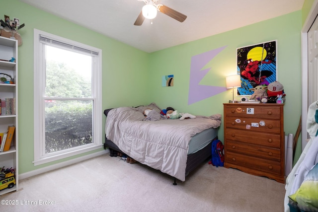 carpeted bedroom with baseboards and a ceiling fan