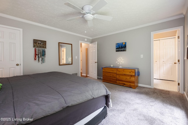 carpeted bedroom with ornamental molding, baseboards, ceiling fan, and a textured ceiling