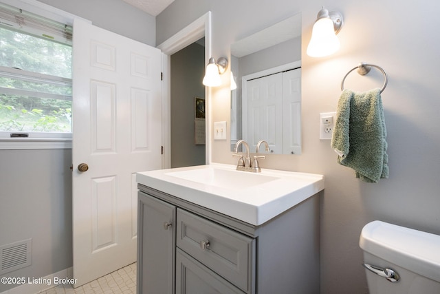 half bathroom featuring vanity and toilet