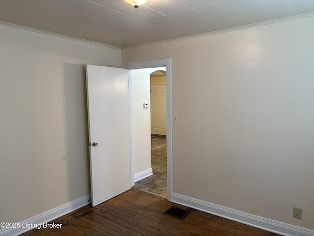 2809 Wyandotte Ave, Louisville, KY 40210 - empty room featuring crown molding, arched walkways, dark wood-style floors, and baseboards