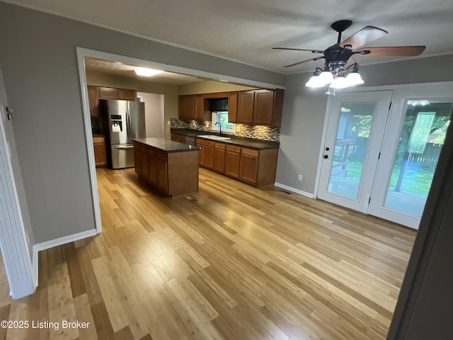 117 Northridge Dr, Bedford, KY 40006 - kitchen featuring stainless steel fridge with ice dispenser, a ceiling fan, dark countertops, light wood-style flooring, and backsplash
