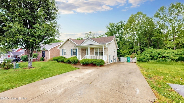 11404 Reality Trl, Louisville, KY 40229 - view of front facade with covered porch, driveway, a front yard, and brick siding