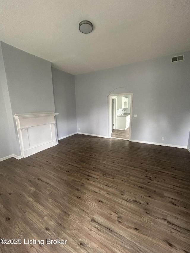 empty room with dark wood-style flooring and baseboards