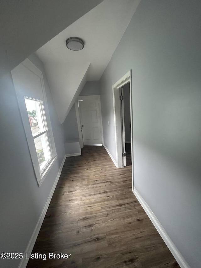 bonus room featuring lofted ceiling, dark wood-style floors, and baseboards