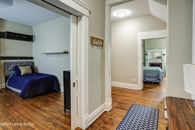 2935 S 3rd St, Louisville, KY 40208 - bedroom with wood finished floors, baseboards, a brick fireplace, and vaulted ceiling