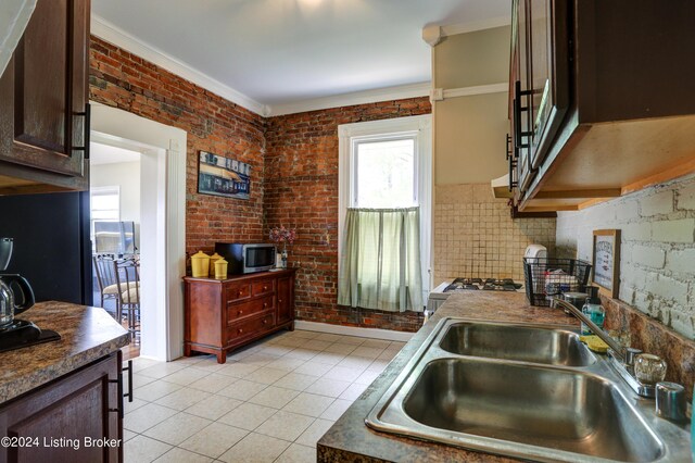 2935 S 3rd St, Louisville, KY 40208 - kitchen featuring a sink, healthy amount of natural light, light tile patterned floors, crown molding, and stainless steel microwave