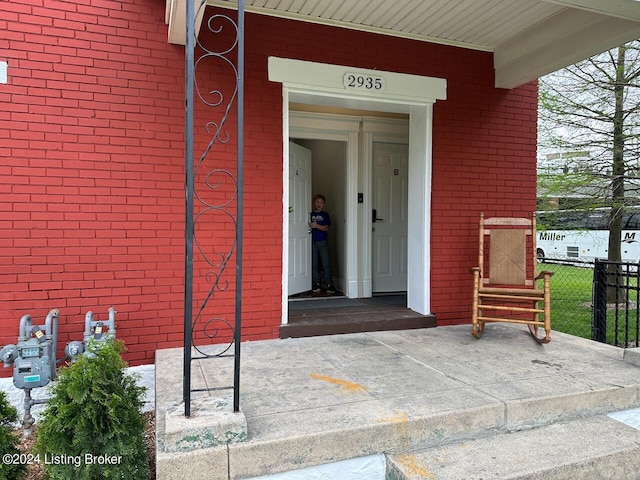 2935 S 3rd St, Louisville, KY 40208 - doorway to property featuring brick siding, a porch, and fence
