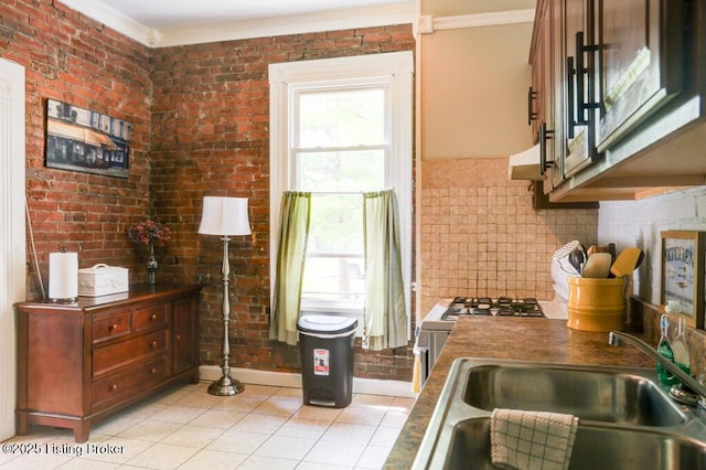 2935 S 3rd St, Louisville, KY 40208 - kitchen with ornamental molding, a sink, light tile patterned floors, under cabinet range hood, and dark countertops