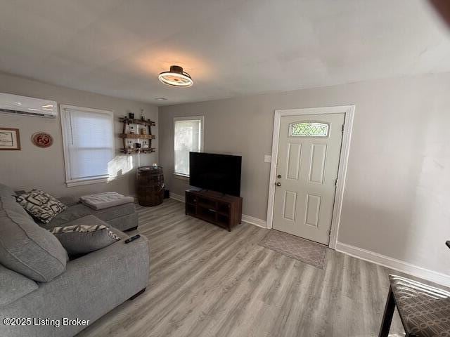 4177 Sherman Ave, Louisville, KY 40213 - living room with an AC wall unit, light wood finished floors, healthy amount of natural light, and baseboards