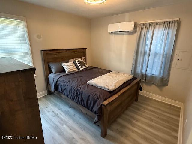 4177 Sherman Ave, Louisville, KY 40213 - bedroom featuring a wall mounted AC, wood finished floors, and baseboards