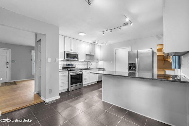 9201 Walhampton Ct, Louisville, KY 40242 - kitchen with appliances with stainless steel finishes, a peninsula, a sink, white cabinets, and backsplash