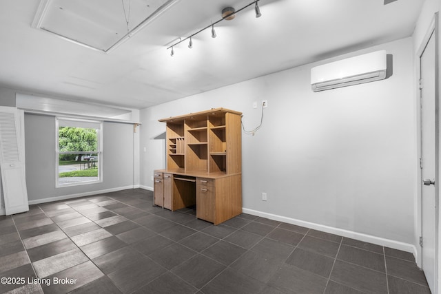 9201 Walhampton Ct, Louisville, KY 40242 - basement featuring a wall unit AC, baseboards, dark tile patterned floors, and rail lighting
