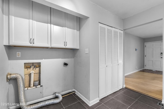 9201 Walhampton Ct, Louisville, KY 40242 - laundry room with electric dryer hookup, cabinet space, dark tile patterned floors, washer hookup, and baseboards