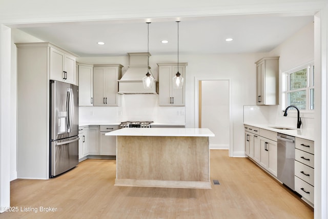 449 S Stallard Dr, Shelbyville, KY 40065 - kitchen featuring appliances with stainless steel finishes, a sink, premium range hood, light wood-type flooring, and a center island