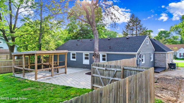 back of house with a patio area and a shingled roof