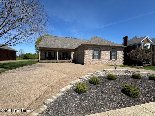 10606 Black Iron Rd, Louisville, KY 40291 - view of front of home featuring a garage, driveway, brick siding, and covered porch