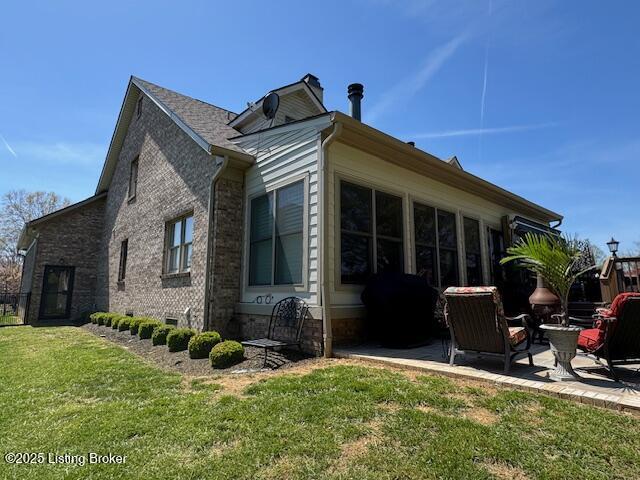 10606 Black Iron Rd, Louisville, KY 40291 - view of home's exterior featuring a lawn, a patio area, and brick siding