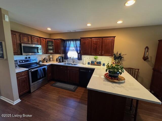 10606 Black Iron Rd, Louisville, KY 40291 - kitchen featuring stainless steel appliances, a peninsula, a sink, light countertops, and recessed lighting