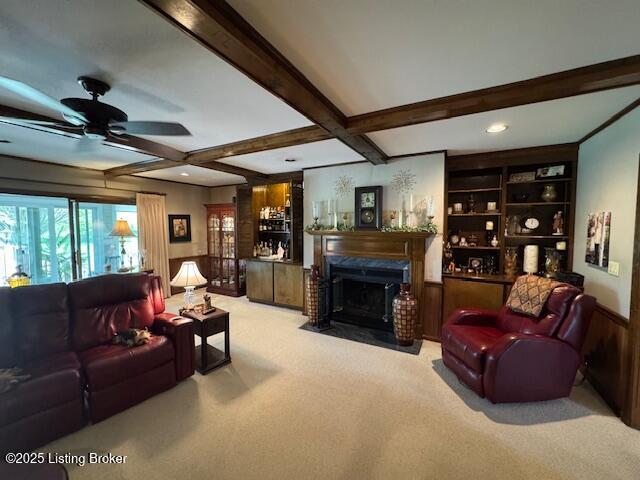 10606 Black Iron Rd, Louisville, KY 40291 - living room featuring carpet, a ceiling fan, beam ceiling, a fireplace with flush hearth, and wainscoting