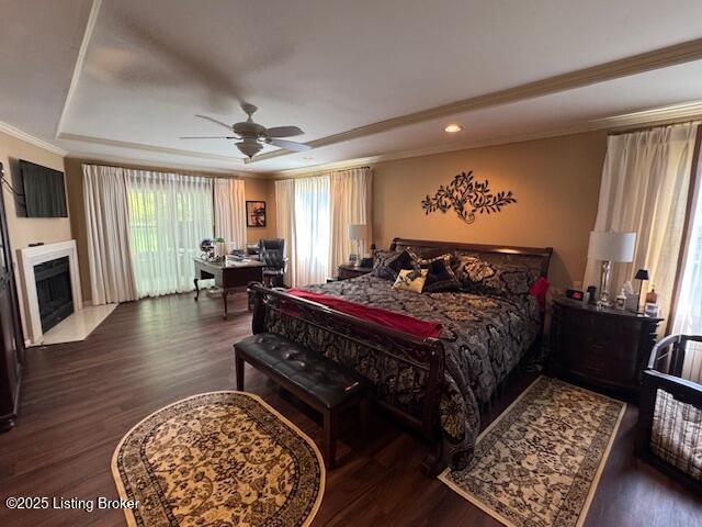 10606 Black Iron Rd, Louisville, KY 40291 - bedroom with a raised ceiling, wood finished floors, ornamental molding, an office area, and a fireplace with flush hearth