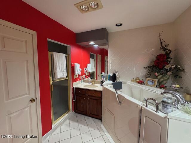 10606 Black Iron Rd, Louisville, KY 40291 - full bathroom featuring tile patterned flooring, washer / dryer, vanity, a garden tub, and a shower stall