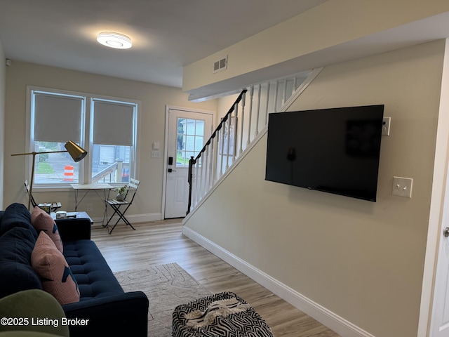 1254 S Preston St, Louisville, KY 40217 - living area with stairway, baseboards, and light wood-style floors