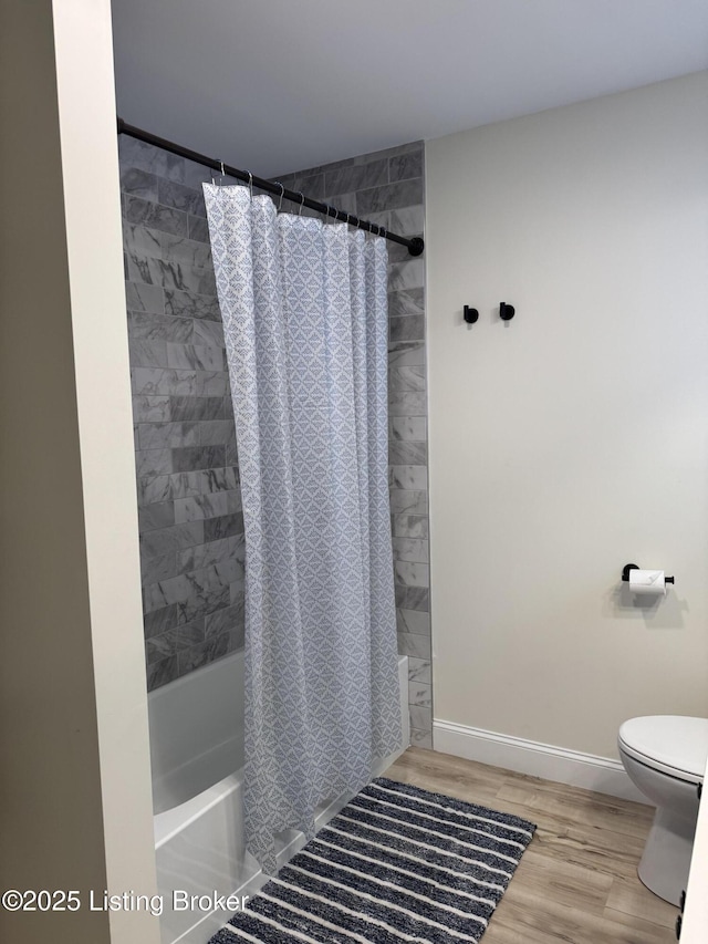 1254 S Preston St, Louisville, KY 40217 - bathroom featuring toilet, shower / bath combo with shower curtain, wood finished floors, and baseboards