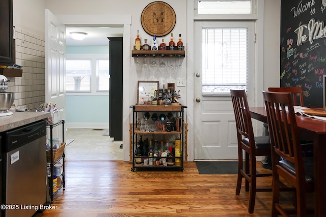 dining room with wood finished floors and a bar