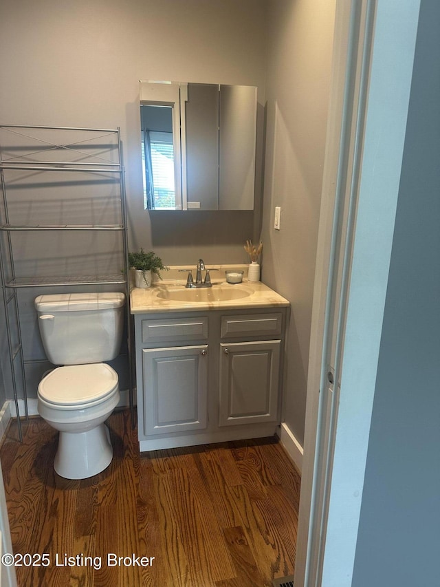 827 Mulberry St, Louisville, KY 40217 - bathroom with toilet, vanity, wood finished floors, and baseboards