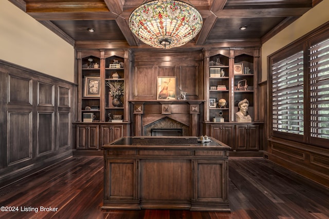 office area with dark wood finished floors, a fireplace, built in features, coffered ceiling, and ornamental molding