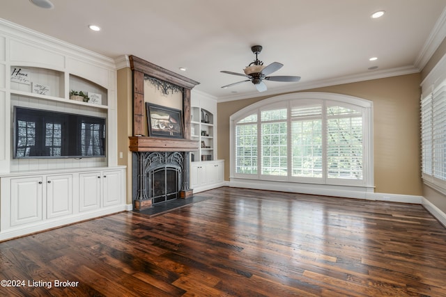 unfurnished living room featuring dark wood-type flooring, plenty of natural light, crown molding, ceiling fan, and a premium fireplace